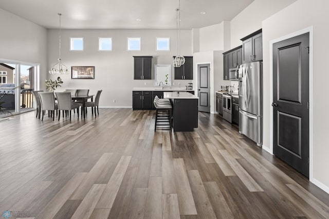 752 Cathy Dr W, West Fargo, ND 58078 - kitchen featuring a kitchen breakfast bar, a kitchen island, stainless steel appliances, an inviting chandelier, and light countertops