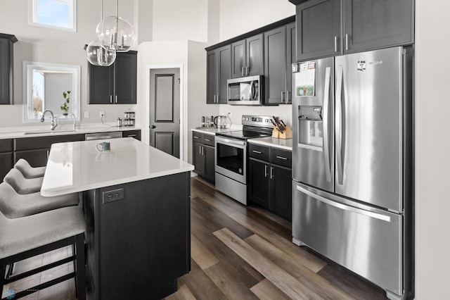 752 Cathy Dr W, West Fargo, ND 58078 - kitchen featuring a kitchen island, a sink, light countertops, appliances with stainless steel finishes, and a kitchen bar