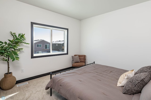 carpeted bedroom with visible vents and baseboards