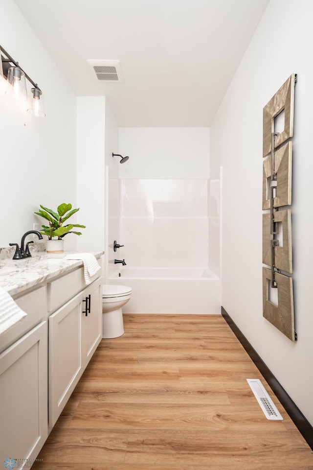 full bath with shower / bath combination, visible vents, toilet, and wood finished floors