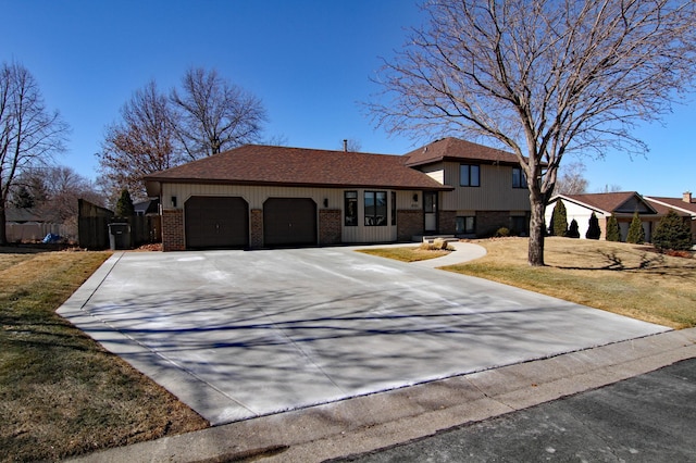 view of front of house with a front yard, brick siding, driveway, and an attached garage