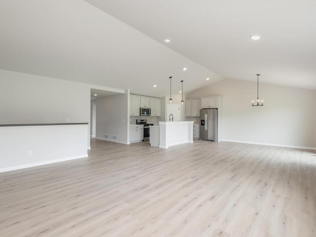 unfurnished living room with a chandelier, baseboards, vaulted ceiling, and light wood finished floors