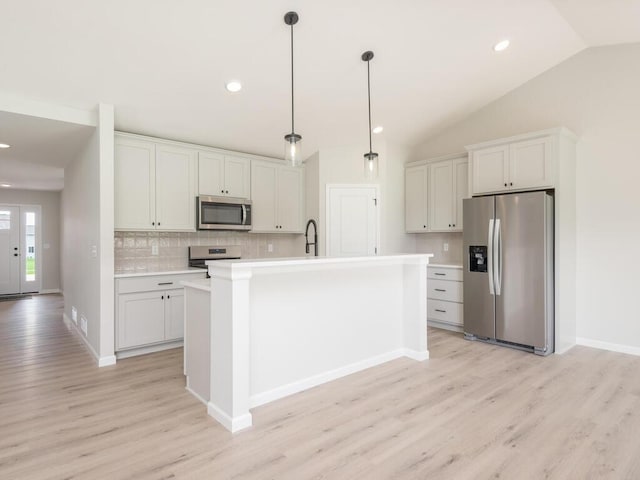 kitchen with lofted ceiling, stainless steel appliances, a sink, light countertops, and decorative backsplash