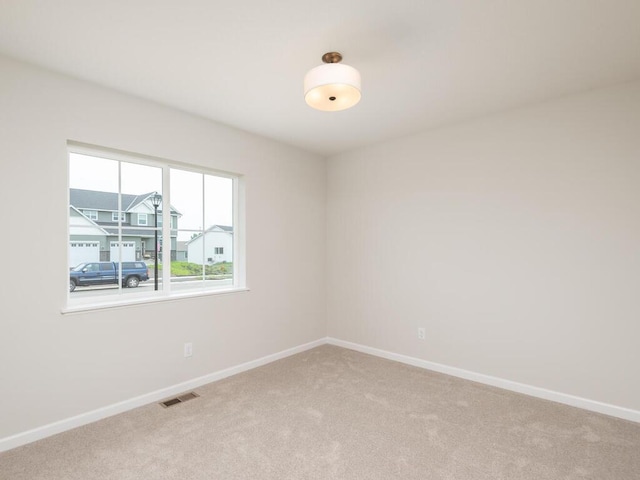 empty room with light carpet, baseboards, and visible vents