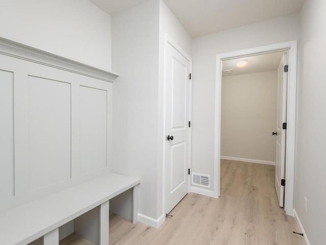 mudroom featuring light wood-style floors, baseboards, and visible vents