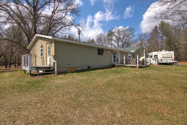 back of property with a yard, crawl space, and a deck