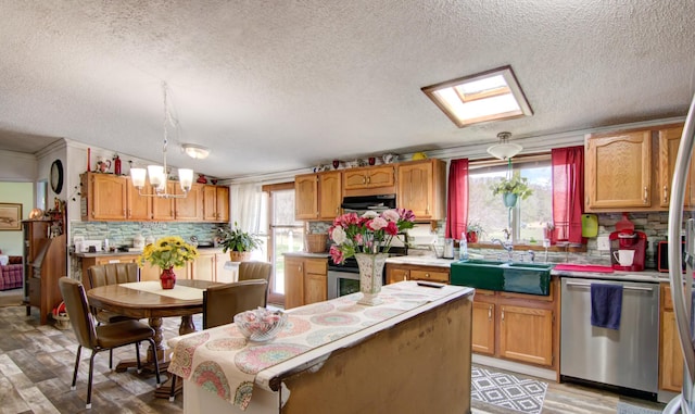 kitchen with exhaust hood, stainless steel appliances, a sink, tasteful backsplash, and a textured ceiling