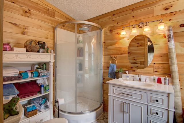 full bathroom with vanity, a textured ceiling, wooden walls, and a stall shower