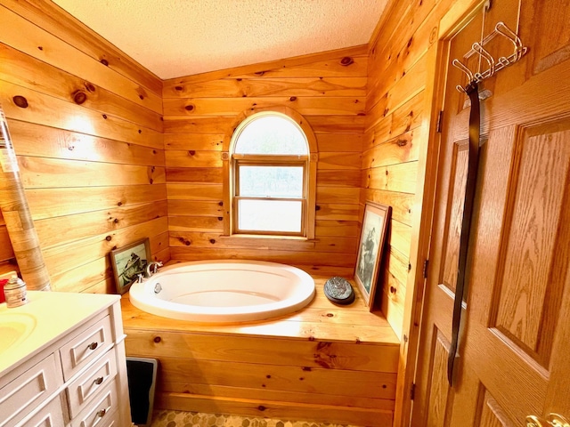 full bath featuring a bath, a textured ceiling, wood walls, and vanity
