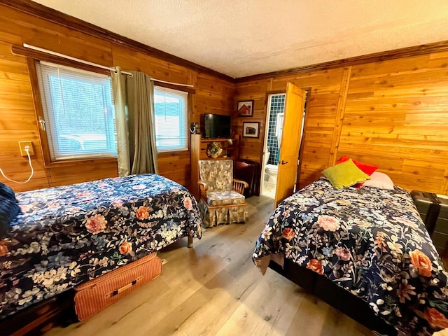 bedroom with wood finished floors, wood walls, and crown molding