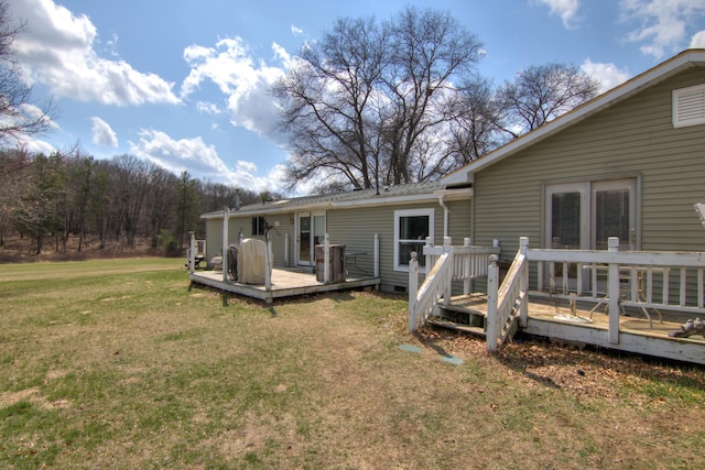 rear view of property with a lawn and a wooden deck