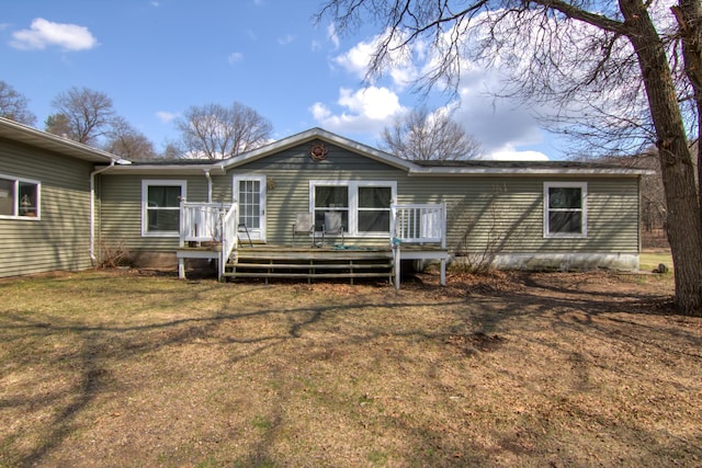 back of property featuring a lawn and a deck