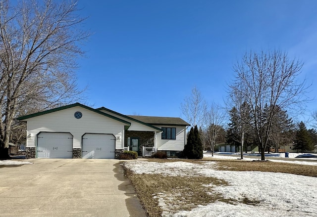 view of front of property featuring concrete driveway, stone siding, and an attached garage