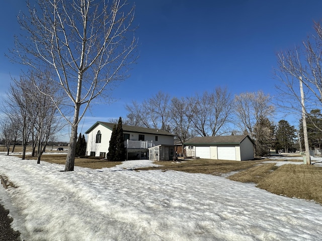 view of front facade featuring an outbuilding, a detached garage, and a deck