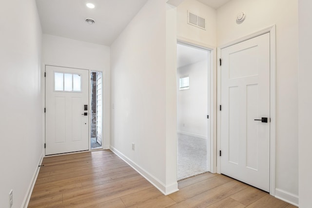 entryway with visible vents, plenty of natural light, light wood-style flooring, and baseboards