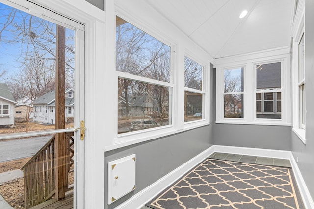 unfurnished sunroom featuring lofted ceiling and a healthy amount of sunlight