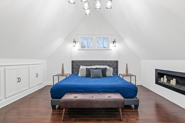 bedroom featuring vaulted ceiling, baseboards, and dark wood finished floors