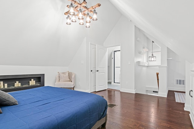 bedroom featuring a notable chandelier, visible vents, baseboards, vaulted ceiling, and hardwood / wood-style floors