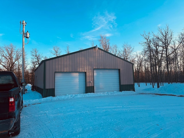 snow covered garage featuring a garage