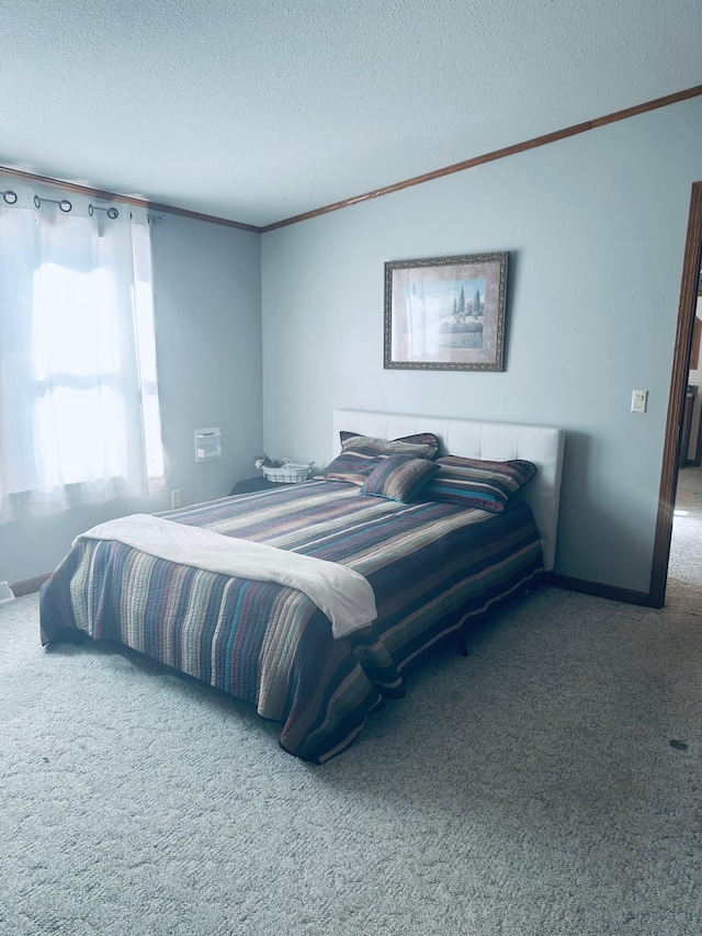 bedroom with carpet floors, a textured ceiling, baseboards, and crown molding