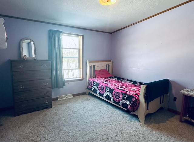 carpeted bedroom featuring baseboards, crown molding, visible vents, and a textured ceiling