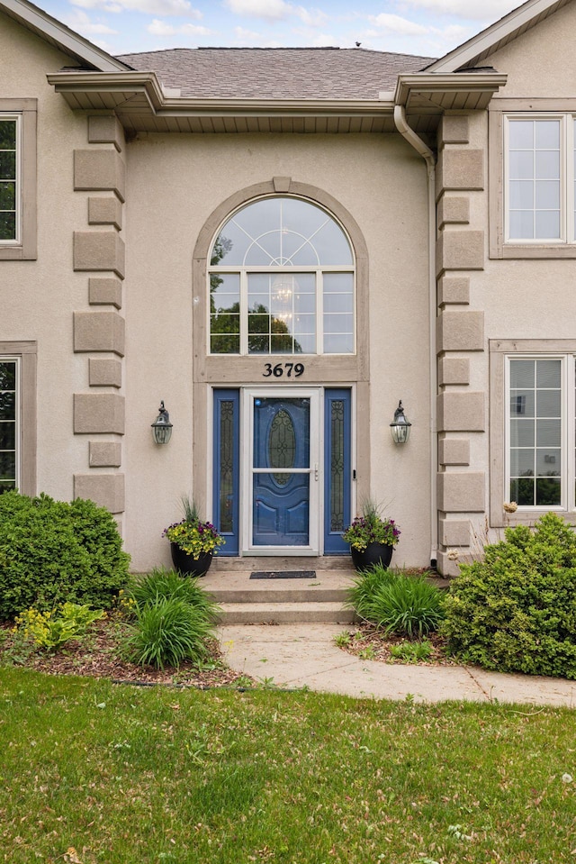 3679 Commonwealth Rd, Woodbury, MN 55125 - doorway to property featuring stucco siding and a lawn