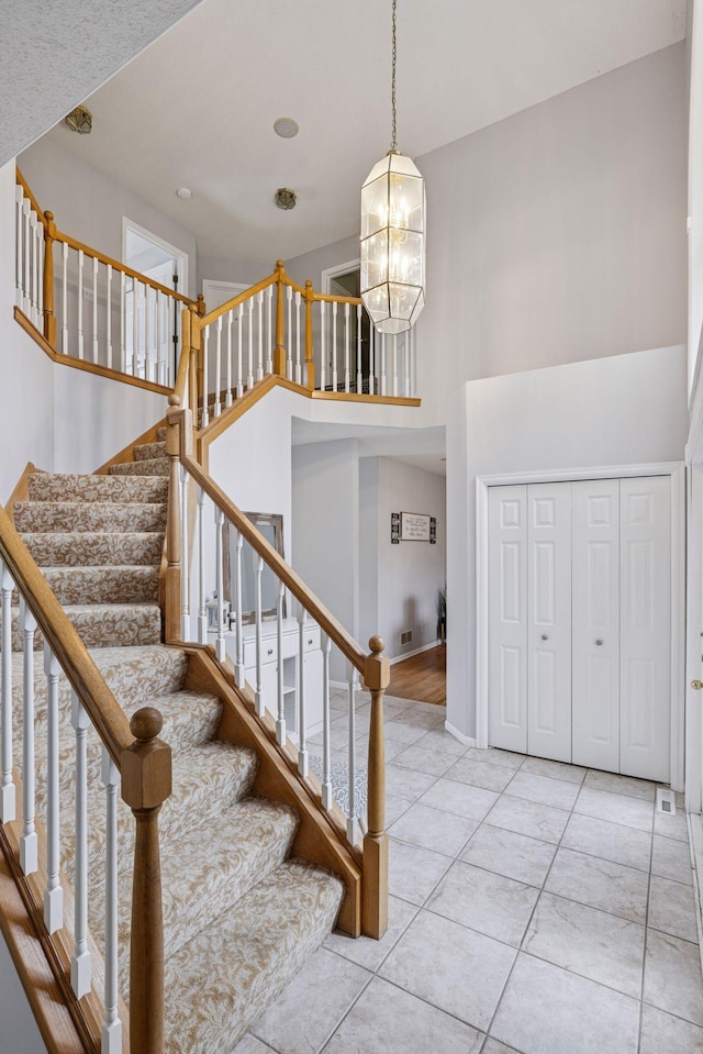 3679 Commonwealth Rd, Woodbury, MN 55125 - staircase with a high ceiling, a chandelier, and tile patterned flooring