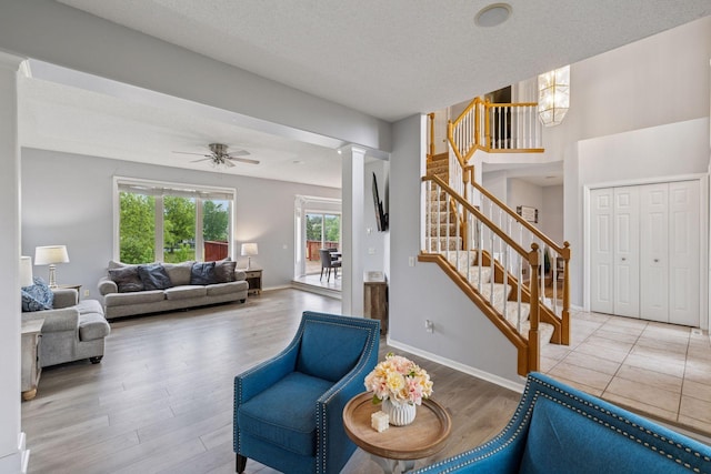 3679 Commonwealth Rd, Woodbury, MN 55125 - living area featuring ornate columns, stairway, wood finished floors, a textured ceiling, and ceiling fan