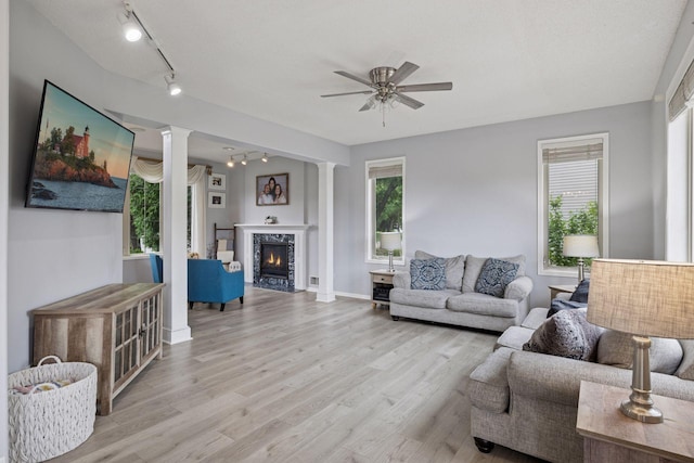 3679 Commonwealth Rd, Woodbury, MN 55125 - living room with rail lighting, decorative columns, ceiling fan, light wood-style flooring, and healthy amount of natural light