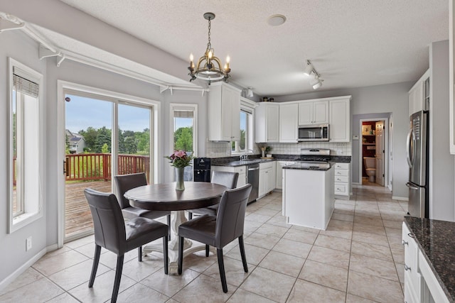 3679 Commonwealth Rd, Woodbury, MN 55125 - dining space featuring a chandelier, a textured ceiling, light tile patterned floors, baseboards, and track lighting