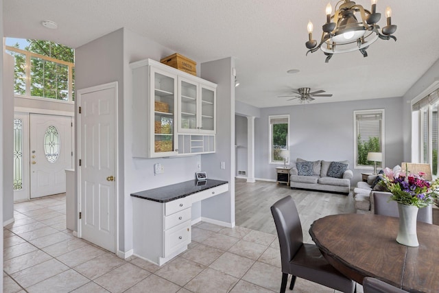 3679 Commonwealth Rd, Woodbury, MN 55125 - kitchen with light tile patterned flooring, a chandelier, white cabinets, and glass insert cabinets