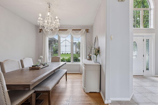 3679 Commonwealth Rd, Woodbury, MN 55125 - dining area with a chandelier, baseboards, and a textured ceiling