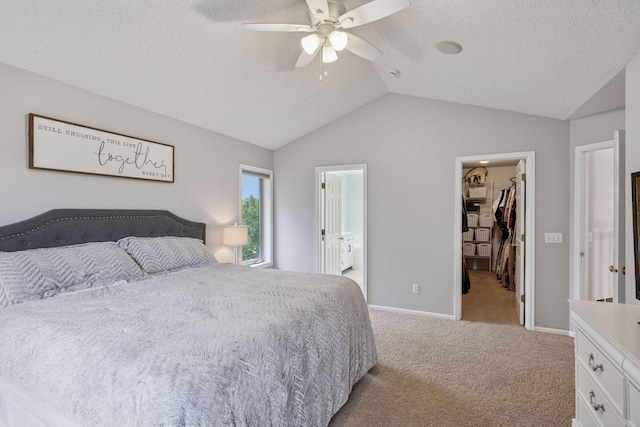 3679 Commonwealth Rd, Woodbury, MN 55125 - carpeted bedroom featuring a walk in closet, vaulted ceiling, a ceiling fan, a textured ceiling, and baseboards