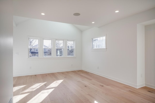 empty room featuring recessed lighting, baseboards, light wood-style floors, and vaulted ceiling