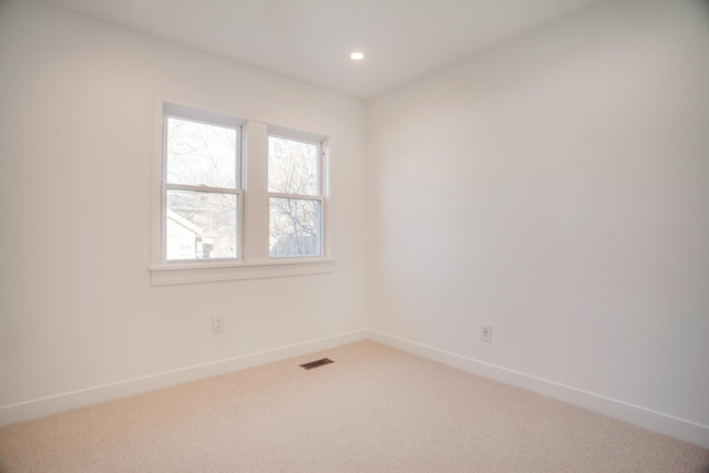 spare room with light carpet, visible vents, recessed lighting, and baseboards