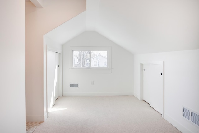 additional living space with visible vents, baseboards, carpet, and vaulted ceiling