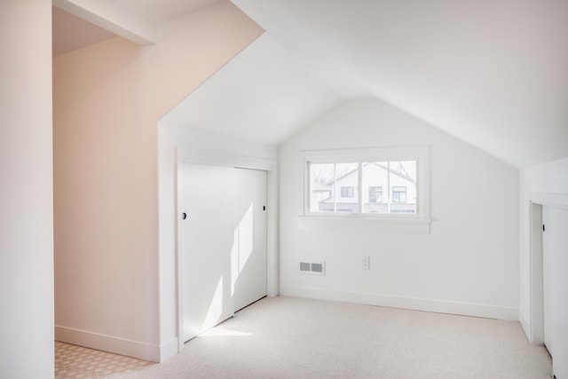 additional living space with visible vents, carpet floors, baseboards, and vaulted ceiling