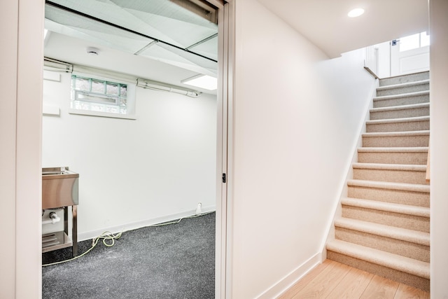 stairs featuring wood finished floors, recessed lighting, and baseboards