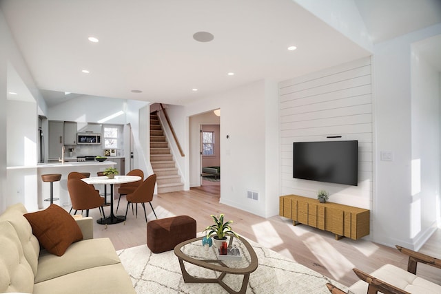 living area with light wood-style floors, stairway, recessed lighting, and visible vents