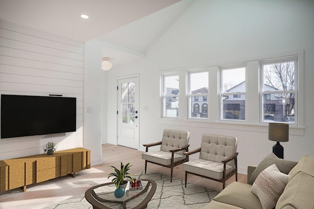 living room featuring a wealth of natural light, lofted ceiling, light wood-style floors, and recessed lighting