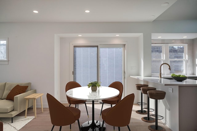 dining space with light wood-style flooring, recessed lighting, and baseboards