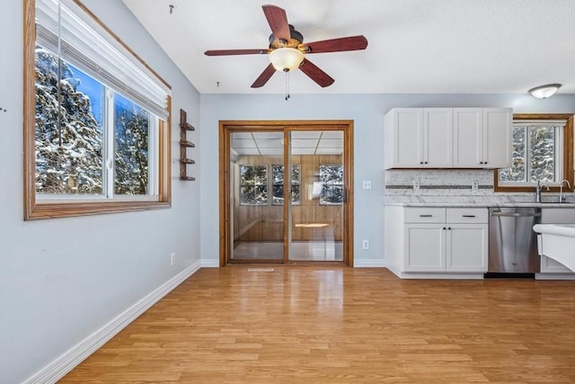 kitchen with light wood-style flooring, white cabinetry, decorative backsplash, and dishwasher