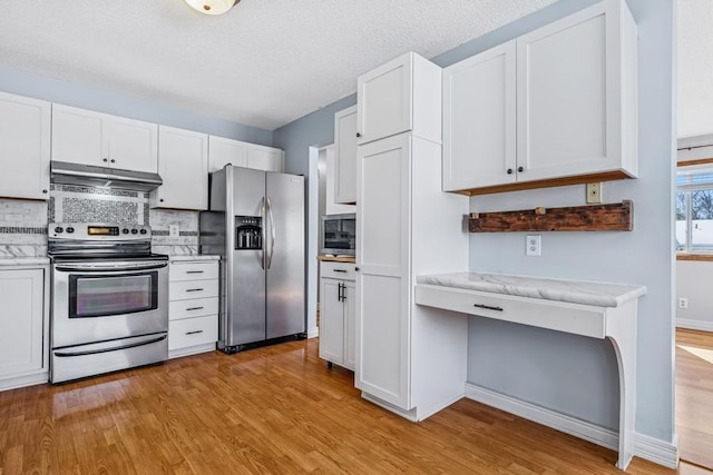 kitchen with under cabinet range hood, light wood-style floors, light countertops, appliances with stainless steel finishes, and tasteful backsplash