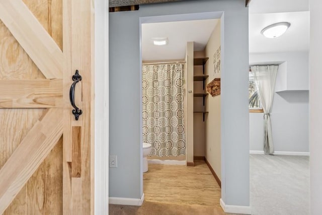 full bathroom featuring a shower with shower curtain, toilet, and baseboards