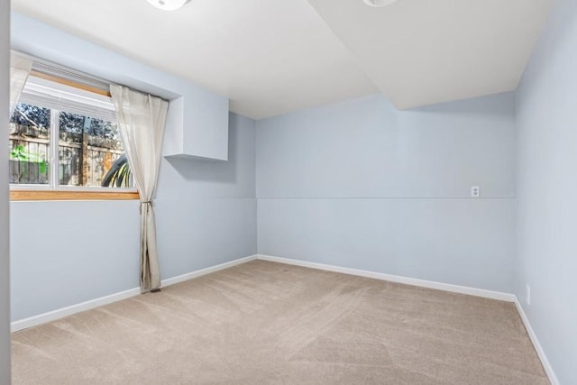 unfurnished room with baseboards and light colored carpet