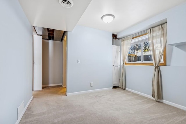 spare room with light carpet, baseboards, and visible vents