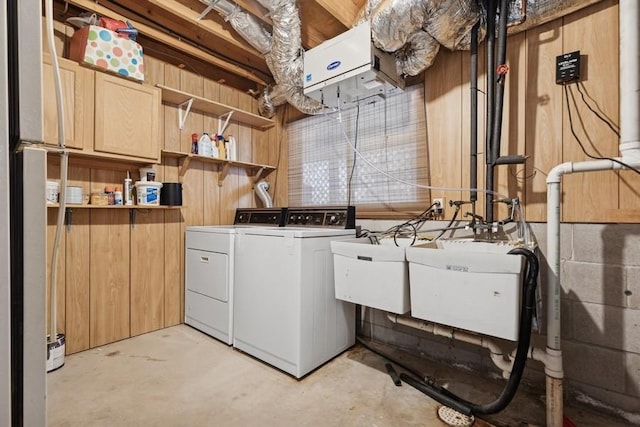 clothes washing area with cabinet space, a sink, and washing machine and clothes dryer