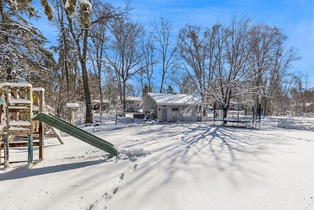 yard covered in snow with a trampoline and playground community