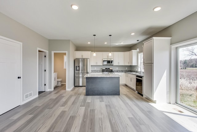 kitchen with visible vents, plenty of natural light, stainless steel appliances, and a sink