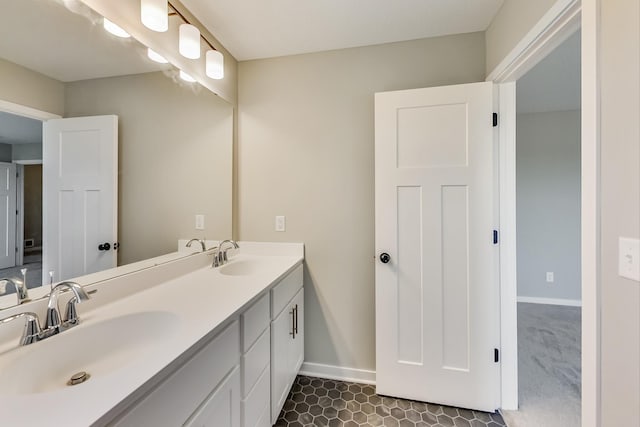 bathroom featuring double vanity, tile patterned flooring, baseboards, and a sink